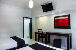 a bedroom with a bed and a desk and a mirror at Hotel Del Valle, Tecamachalco in Tecamachalco +50 photos