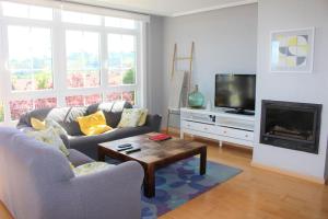 a living room with a couch and a tv at VibesCoruña - Varsovia 3 in A Coruña