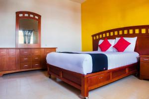 TecamachalcoにあるCapital O Del Valle, Tecamachalcoのベッドルーム1室(赤い枕と鏡付きのベッド1台付)