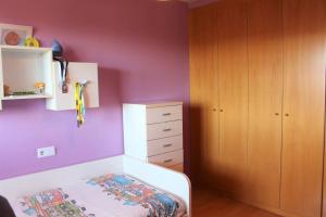 a bedroom with purple walls and a bed and a dresser at VibesCoruña - Varsovia 3 in A Coruña