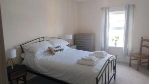 a bedroom with a white bed with towels on it at The Snug in Amlwch