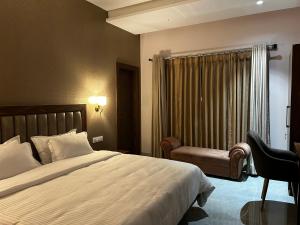 een hotelkamer met een bed en een stoel bij Ashirvad Homestay Varanasi in Varanasi