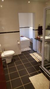 łazienka z toaletą, umywalką i wanną w obiekcie Casa Bianca Guest Lodge w mieście Hartbeespoort