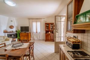 a kitchen and a living room with a table at Agriturismo Giù al Pozzo in Gavorrano