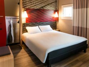 ein Schlafzimmer mit einem großen weißen Bett in einem Zimmer in der Unterkunft ibis Bourg en Bresse in Bourg-en-Bresse