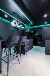 a kitchen with green lighting and a table and chairs at Luxury Couples Get-Away Glasgow in Knightswood
