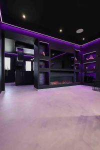 a large room with a stage with purple lighting at Luxury Couples Get-Away Glasgow in Knightswood