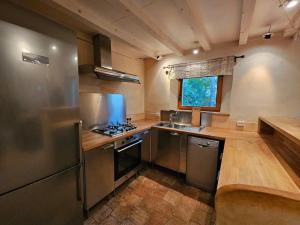eine Küche mit Küchengeräten aus Edelstahl und einem Fenster in der Unterkunft Maison au pied des Alpilles - Paradou in Paradou
