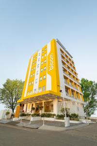 ein großes gelbes und weißes Hotelgebäude auf einer Straße in der Unterkunft Bloom Hotel - Ranchi in Ranchi