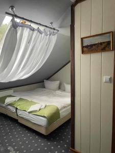 1 dormitorio con 1 cama con dosel en Hotel Kęszyca Leśna, en Kęszyca