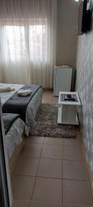 ein kleines Schlafzimmer mit einem Bett und einem Tisch in der Unterkunft Vila Alexandru in Eforie Nord