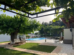 a patio with a tree and a swimming pool at Stancia Rosa - cozy apartment in Poreč