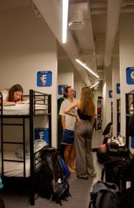 a group of people standing in a room with bunk beds at CheapSleep Hostel Helsinki in Helsinki