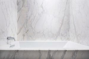 a white tub in a bathroom with a marble wall at Hyatt Centric Midtown Atlanta in Atlanta