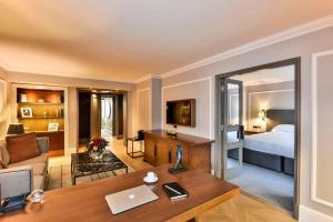 a living room with a bed and a desk with a laptop at Hyatt Regency London - The Churchill in London