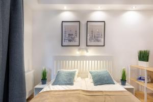 a bedroom with a bed with three pictures on the wall at Downtown Nature Apartment in Budapest