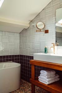 a bathroom with a tub and a sink at Hôtel Maison Lacassagne Lyon in Lyon