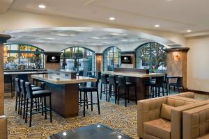 un bar avec tabourets et tables dans un restaurant dans l'établissement DoubleTree by Hilton San Pedro, à San Pedro