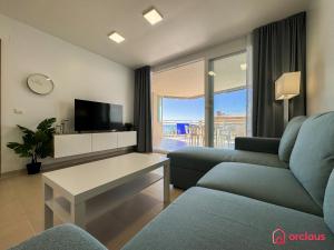 Una sala de estar con un sofá y un televisor. en Aqua Turquesa, en Oropesa del Mar