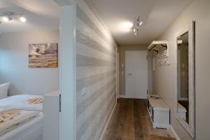 a bedroom with a wall covered in wood at Ferienwohnung Buhne73 in Wenningstedt