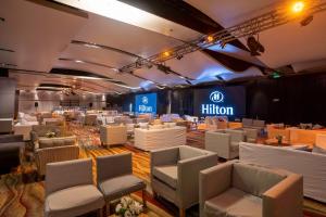 a hall with white chairs and a hilton sign on the wall at Hilton Buenos Aires in Buenos Aires +58 photos