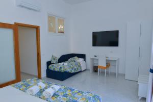salon z 2 łóżkami i telewizorem w obiekcie Casa Natalia w Sorrento
