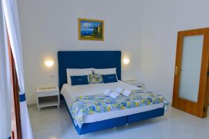 a bedroom with a large bed with a blue headboard at Casa Natalia in Sorrento