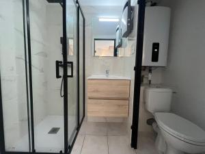 een badkamer met een douche, een toilet en een wastafel bij Idéal pour vos vacances a in Aigues-Mortes