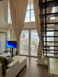 salon z białą kanapą i dużym oknem w obiekcie Arkipelago Beach Resort w mieście Puerto Galera