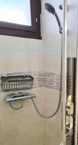 a shower in a bathroom with a glass door at Superbe T2 climatisé, proche plage avec parking privé in Saint-Cyprien