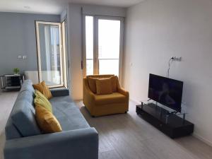 uma sala de estar com um sofá azul e uma cadeira em Paradise Dream 3 Apartment in Vlora em Vlorë