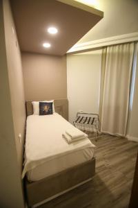 Un pat sau paturi într-o cameră la ÇEVİK PALACE HOTEL