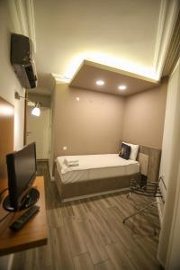 ÇEVİK PALACE HOTEL في أنطاليا: غرفة نوم بسرير وتلفزيون في غرفة
