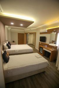Un pat sau paturi într-o cameră la ÇEVİK PALACE HOTEL
