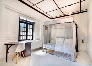 a bedroom with a bed and a desk and a window at Lost & Found - Colombo in Colombo