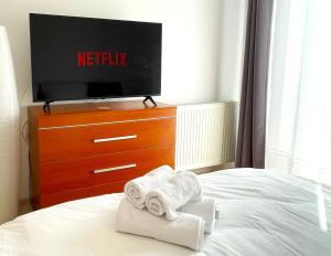a bedroom with a tv and towels on a bed at Bella Vista Studio with Balcony in Braşov