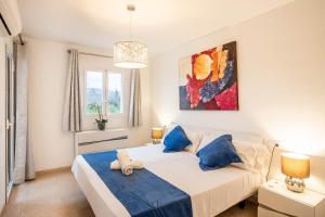 a bedroom with a white bed and blue pillows at Estrella Bahia in Port d'Alcudia