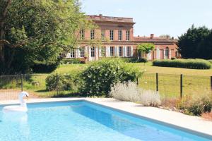 a swan in a swimming pool in front of a house at Chambre hôte double 1 in Castelsarrasin