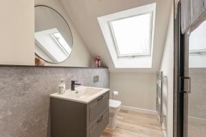 a bathroom with a sink and a mirror at Stylish 1 Bedroom Apartments Free Parking Good Location in Derby