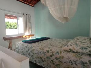 1 dormitorio con cama y ventana en Casa INTI de Maracajaú en Maracajaú