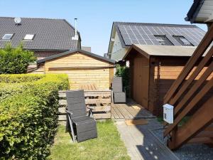 un patio con 2 sillas y un edificio con paneles solares en Obere Sonnsibar, en Fehmarn