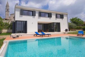 a villa with a swimming pool in front of a house at Modern Villa Anna with outdoor pool in Visnjan in Višnjan