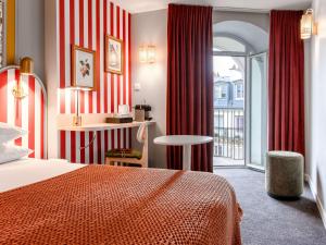 um quarto de hotel com uma cama e uma varanda em Mercure Paris Notre Dame Saint Germain des Prés em Paris