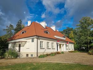 una gran casa blanca con techo rojo en Muzeum Ziemiaństwa w Dąbrowie, en Przesmyki