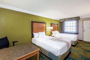 a hotel room with two beds and a desk at La Quinta Inn by Wyndham Amarillo Mid-City in Amarillo