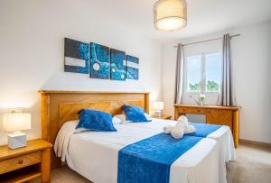 Un dormitorio con dos camas con almohadas azules. en Estrella Coral 12A, en Alcudia
