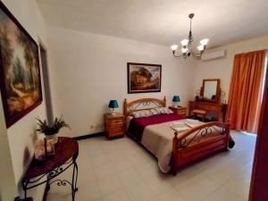 a bedroom with a bed and a chandelier at Unique Mellieha views, Sea Breeze in Mellieħa