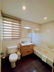 a bathroom with a toilet and a sink and a tub at Unique Mellieha views, Sea Breeze in Mellieħa