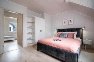 a bedroom with a large bed with pink pillows at Apartamenty Lagos in Karwia