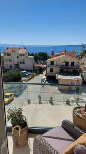 a balcony with a view of a parking lot and the ocean at Apartments iris in Brela
